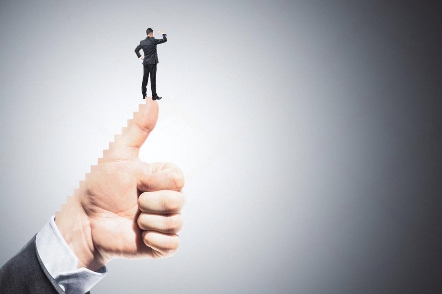 Small figure of a professional standing on a giant thumbs-up, representing recognition earned through upskilling